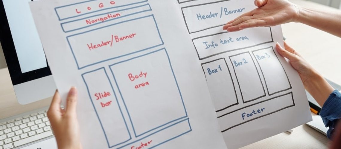 Team of UX designer discussing two versions of mobile device website variant at meeting